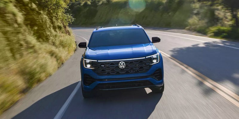 2026 Volkswagen Atlas Cross Sport front view driving on winding road