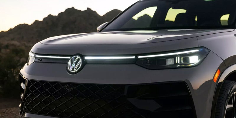 Front grille and LED headlights of the 2026 Volkswagen Tiguan at dusk.